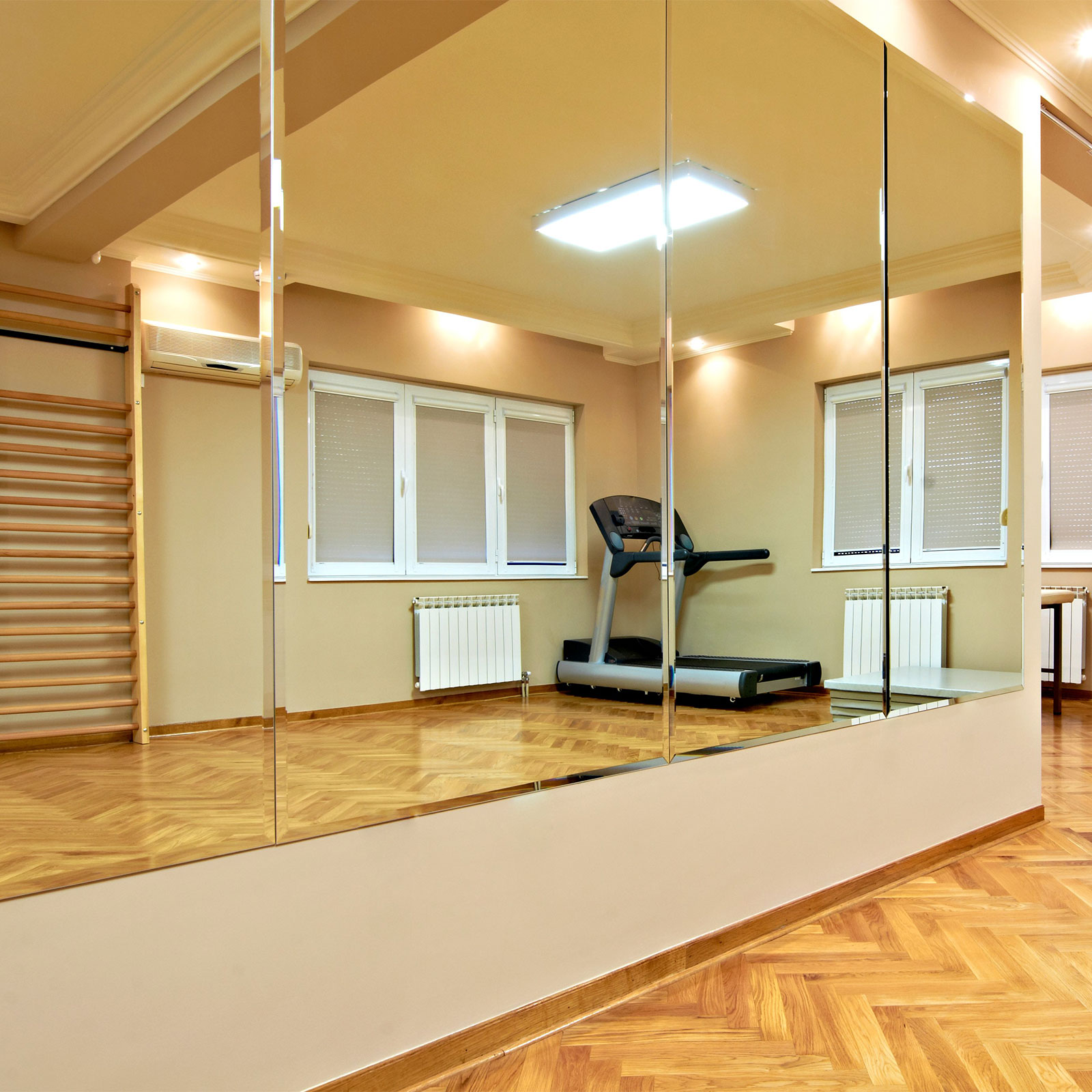 Ein großer Spiegel zeigt den Trainingsraum einer Tanzschule, mit verschiedenen Geräten.